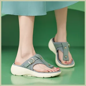 Detail view of platform flip-flops with green knit texture and gold buckle accents