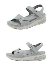 Detail view of grey-blue wedge sandals with velcro straps and contrast stitching