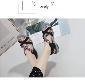 Details von flachen Ethno-Sandalen mit verstellbarem Riemen und gemusterten Kreuzbändern