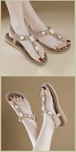 Détails de sandales plates en T abricot avec pierres blanches et strass brillants décoratifs