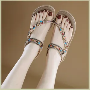 Detalle de sandalias planas bohemias con cuentas de colores y diseño étnico trenzado