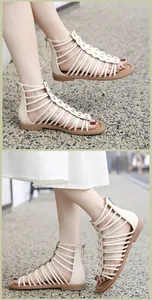 Detail of beige Roman strappy sandals with laser-cut rings and back zipper closure