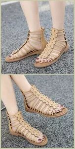 Close-up of khaki gladiator sandals with wavy decorative patches and rear zipper closure