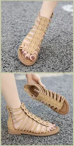 Detail view of khaki gladiator sandals with snake pattern straps and rear zipper