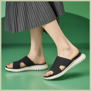 Nahaufnahme von schwarzen Strick-H-Riemen-Plateausandalen mit Rock an einem Model