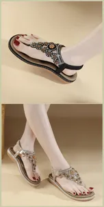 Detail des ethnischen Strass-Blumenmusters auf diesen flachen Zehentrenner-Sandalen
