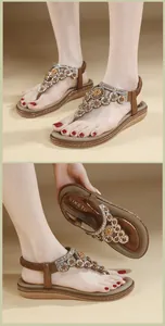 Detail von böhmischen flachen Sandalen mit aufwendigen Strass-Blumenperlen und T-Riemen