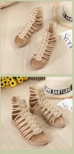 Close-up of beige platform roman sandals with cutout details and rear zip closure