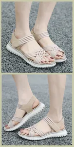 Detailoverzicht van beige gevlochten elastische sandalen met dikke witte profielzool buiten