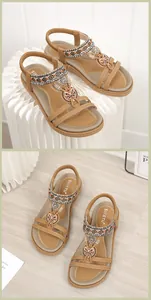 Detail von Boho-Flachsandalen mit Ethno-Webung, bunten Perlen und Schmetterlings-Metalldekor