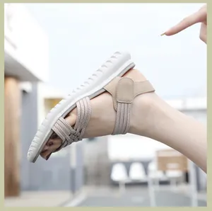 Detail van beige elastisch geweven damessandalen met een dikke witte antislip platformzool