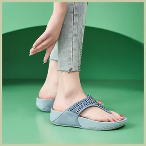 Primer plano de sandalias con plataforma azul claro y pedrería sobre vaqueros