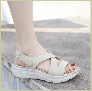 Outdoor shot of beige platform wedge sandals with cross-strap design and thick non-slip soles