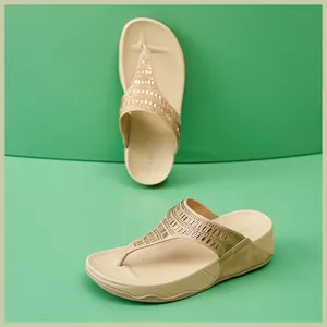 Detalle de sandalias beige con pedrería mostrando la suela de plataforma cómoda