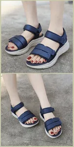 Detail view of women's navy blue sports sandals with thick white cushioned soles and velcro