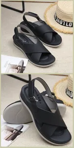 Detail of black wedge sandals featuring cross straps and adjustable heel buckles