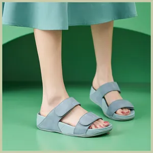 Detail of grey-blue platform wedge sandals with adjustable velcro straps on a model