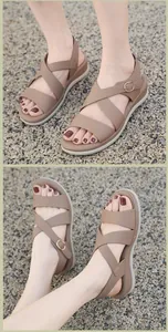 Makro-Detail brauner Plateau-Sandalen mit breiten Kreuzriemen und goldener Schnalle