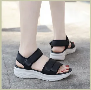 Detail of black sporty platform sandals with adjustable velcro straps on a female model