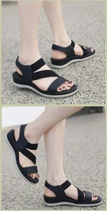 Sandales compensées noires pour femme avec brides croisées et semelle plateforme grise en extérieur