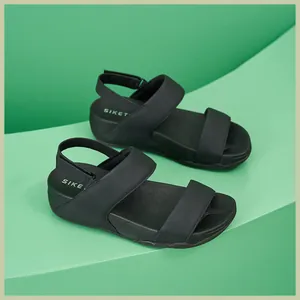 Dettaglio dei sandali neri con zeppa e plateau con cinturino in velcro regolabile
