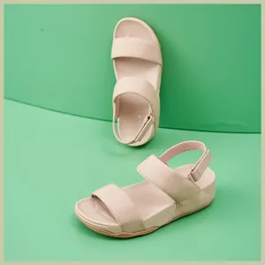 Dettaglio dei cinturini in velcro regolabili e del tessuto beige dei sandali platform