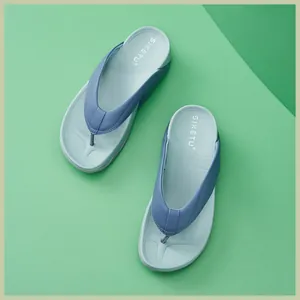 Draufsicht auf Plateau-Flip-Flops mit hellblauer Sohle und violettem Riemendetail