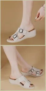 Detalle de sandalias de cuña crema con hebillas decorativas de metal negro y dorado