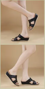 Detalle de sandalias negras con cuña para mujer con correas dobles y hebillas metálicas fijas
