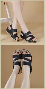 Detalle de sandalias negras de cuña con diseño de tiras cruzadas y hebilla ajustable