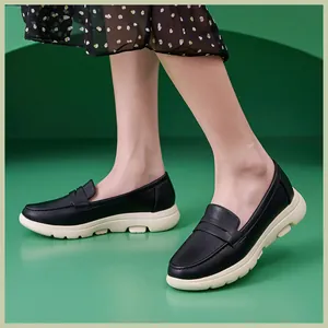Nahaufnahme schwarzer Leder-Loafer mit cremefarbener Plateausohle zum Blumenkleid