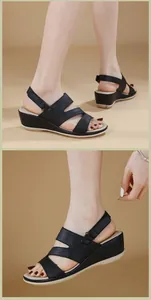 Detalle de sandalias de cuña negras con tiras de cuero granulado y cierre de velcro