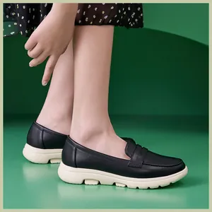 Damen Loafer in Schwarz mit klobigen cremeweißen Softsohlen, am Fuß im Studio präsentiert