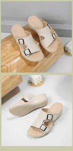 Detalle de sandalias de cuña beige con hebillas metálicas negras y suela antideslizante