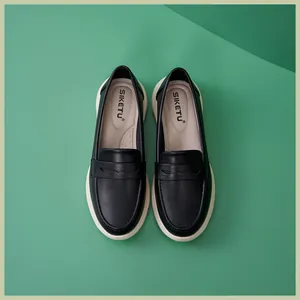 Nahaufnahme schwarzer Leder-Loafer mit weißer Plateausohle und Penny-Strap-Detail