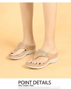Détail de sandales compensées avec motifs floraux ajourés et boucles métalliques
