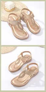 Dettaglio di sandali con zeppa boho con foglie metalliche dorate e cinturino a T