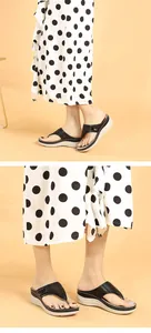 Détail de sandales compensées pour femmes avec motifs ajourés et semelles blanches