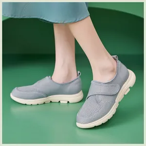 Détail de mocassins en maille grise avec bride velcro et semelle antidérapante