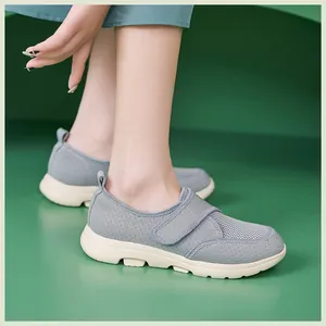 Détail de chaussures en maille grise avec patte auto-agrippante et semelle antidérapante