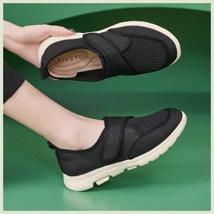 Détail d'une chaussure en maille noire respirante avec bride velcro et semelle antidérapante