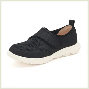 Vue latérale de baskets en maille respirante noire avec bandes velcro et semelles blanches