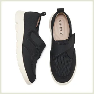 Détail de mocassins en maille noire respirante avec semelles blanches antidérapantes