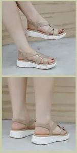Dettaglio di sandali beige con zeppa e cinturini incrociati decorati con strass lucidi