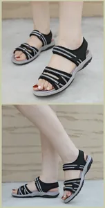 Detailansicht schwarzer Sportsandalen mit weißen Pfeilnähten und Klettverschlussgurten