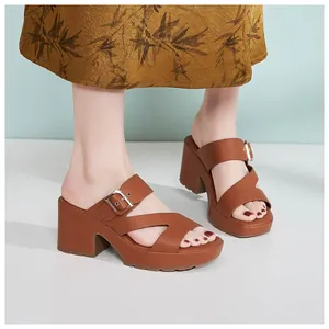Detail of brown platform sandal with crisscross straps and metal buckle on model