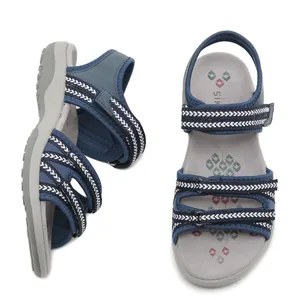 Dunkelblaue Sportsandalen mit Klettverschluss und gemusterter Sohle auf weißem Grund