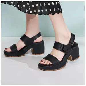 Primer plano de sandalias de cuña negras con tiras acolchadas y cierre de velcro