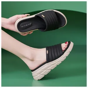 Dettaglio dei sandali platform da donna con cinturini neri trapuntati e suola antiscivolo