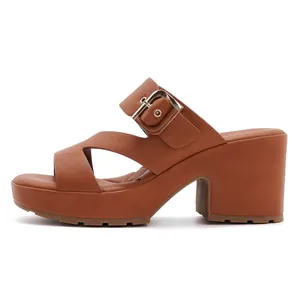 Detailed side view of brown platform mule with gold buckle and crisscross straps